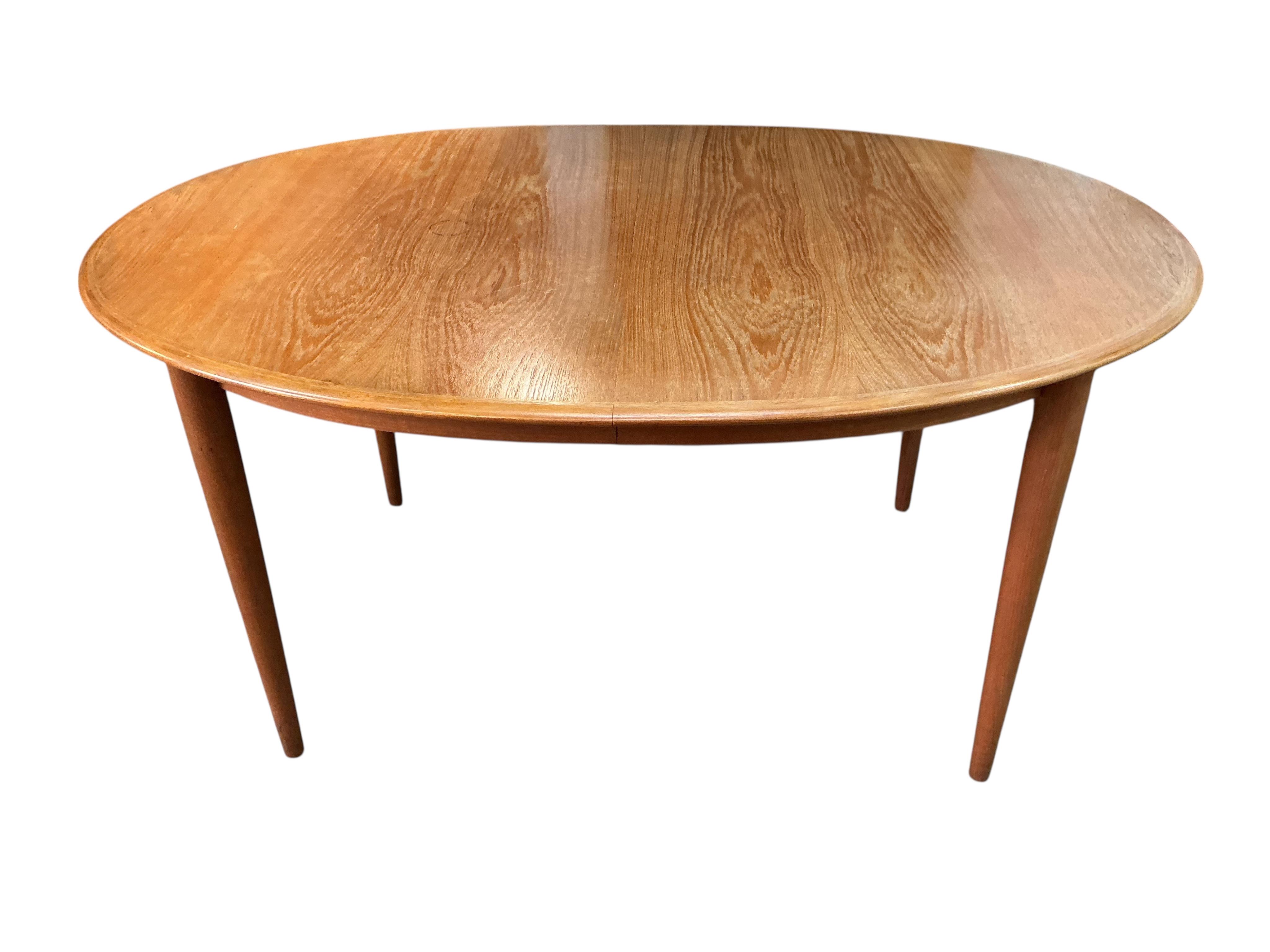 A Danish mid century dining table by Koefoeds-Hornslet, width 250cm extended, two spare leaves, depth 104cm, height 71cm, together with six chairs, two with arms